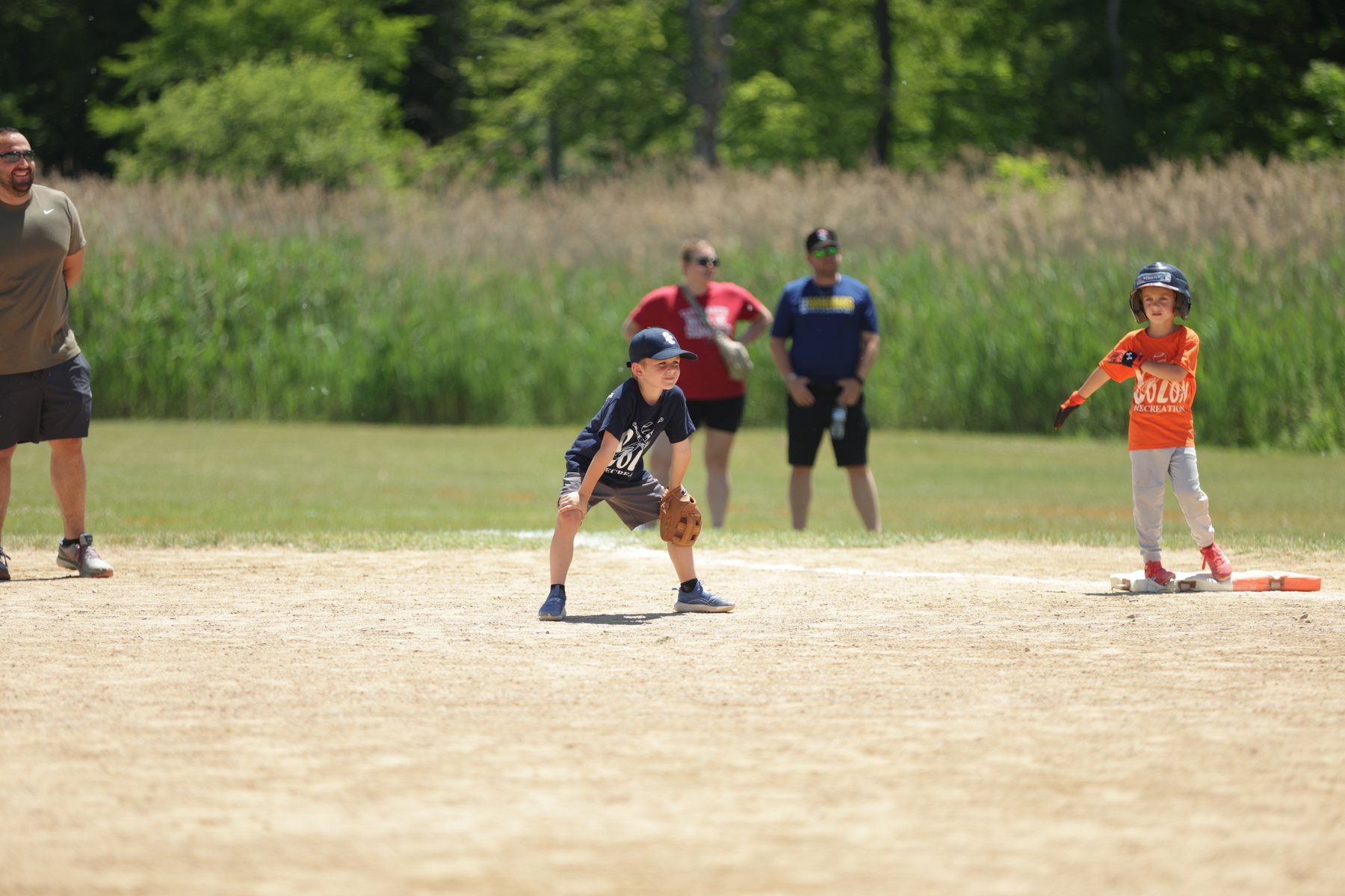 Youth baseball action on a summer field.