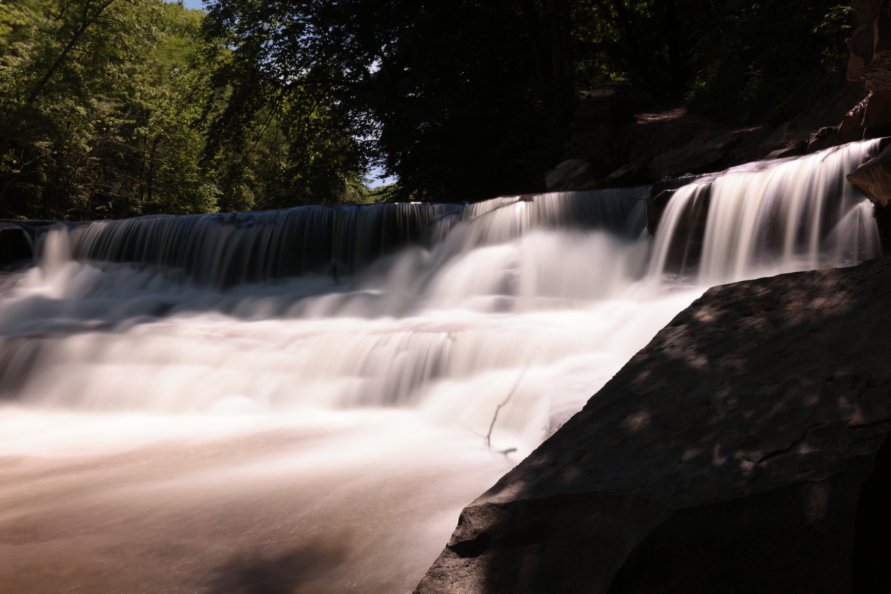 Smooth long-exposure water moving over a falls.