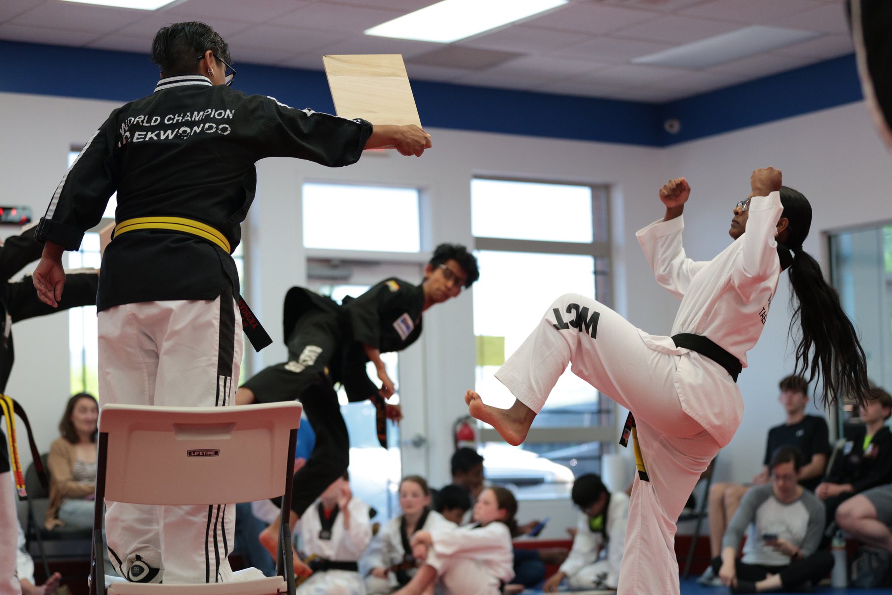 Martial arts student breaking a board during a local event.