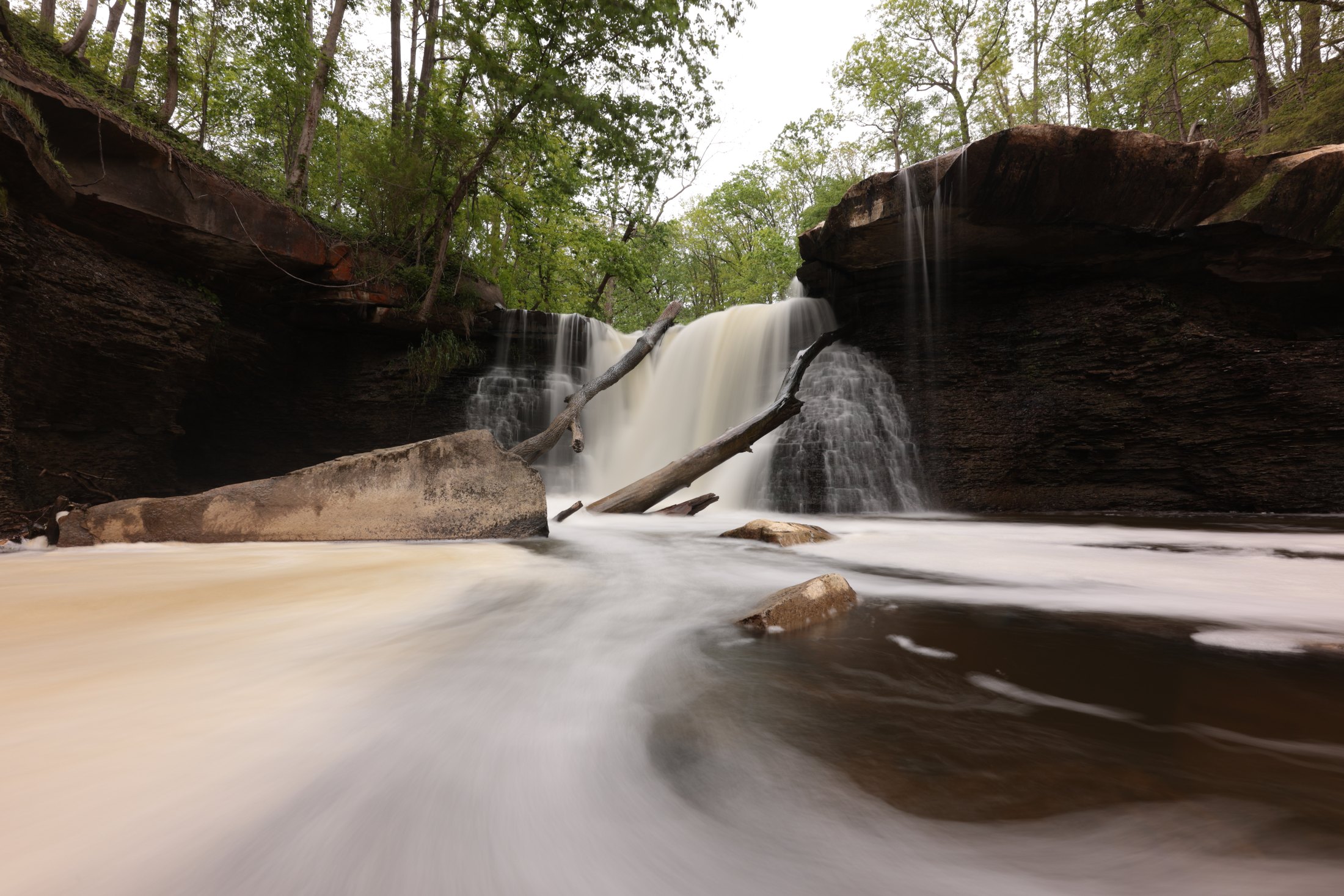 Long-exposure waterfall running between rock walls.