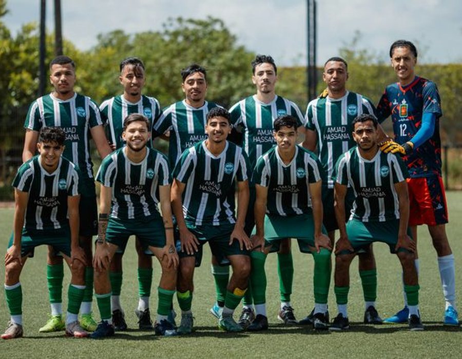 Soccer team posing together for a team photo on the field.