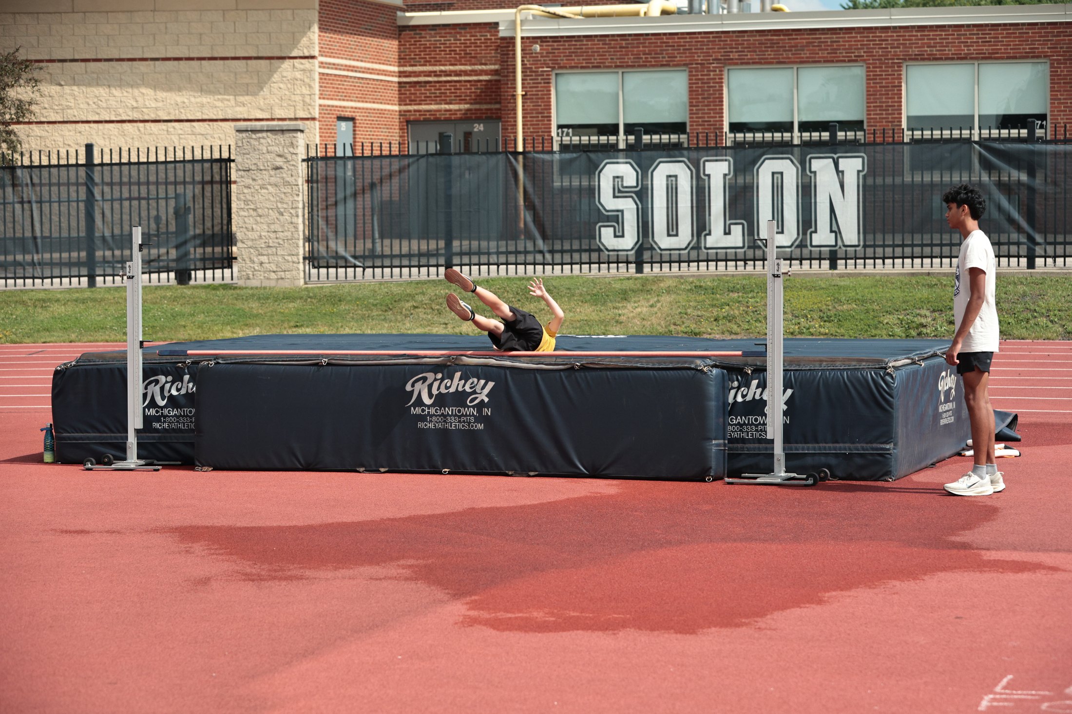 High jumper clearing the mat during a track event.