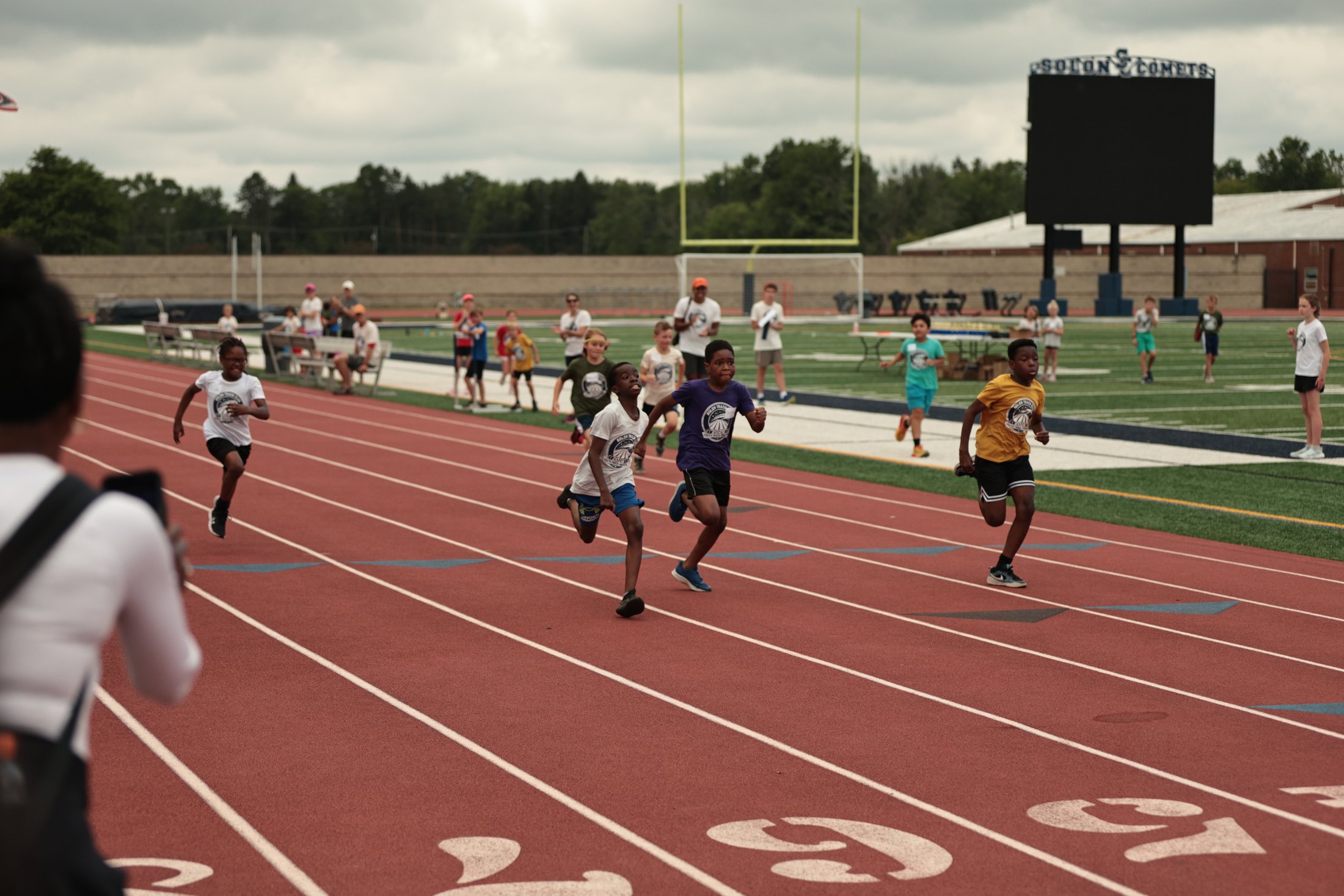Runners breaking from the start of a track race.
