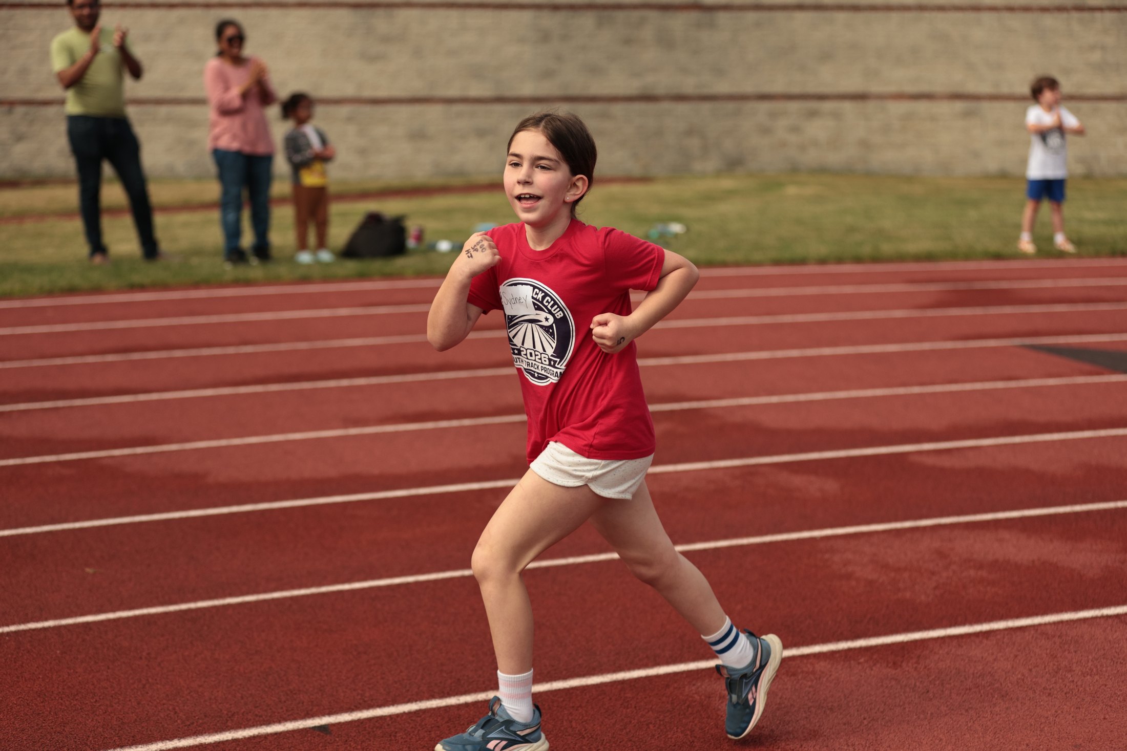 Runner in red moving down the track.