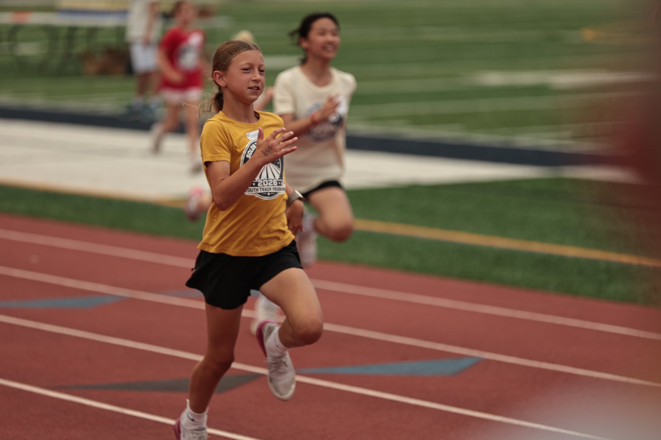 Young runners sprinting during a track event.